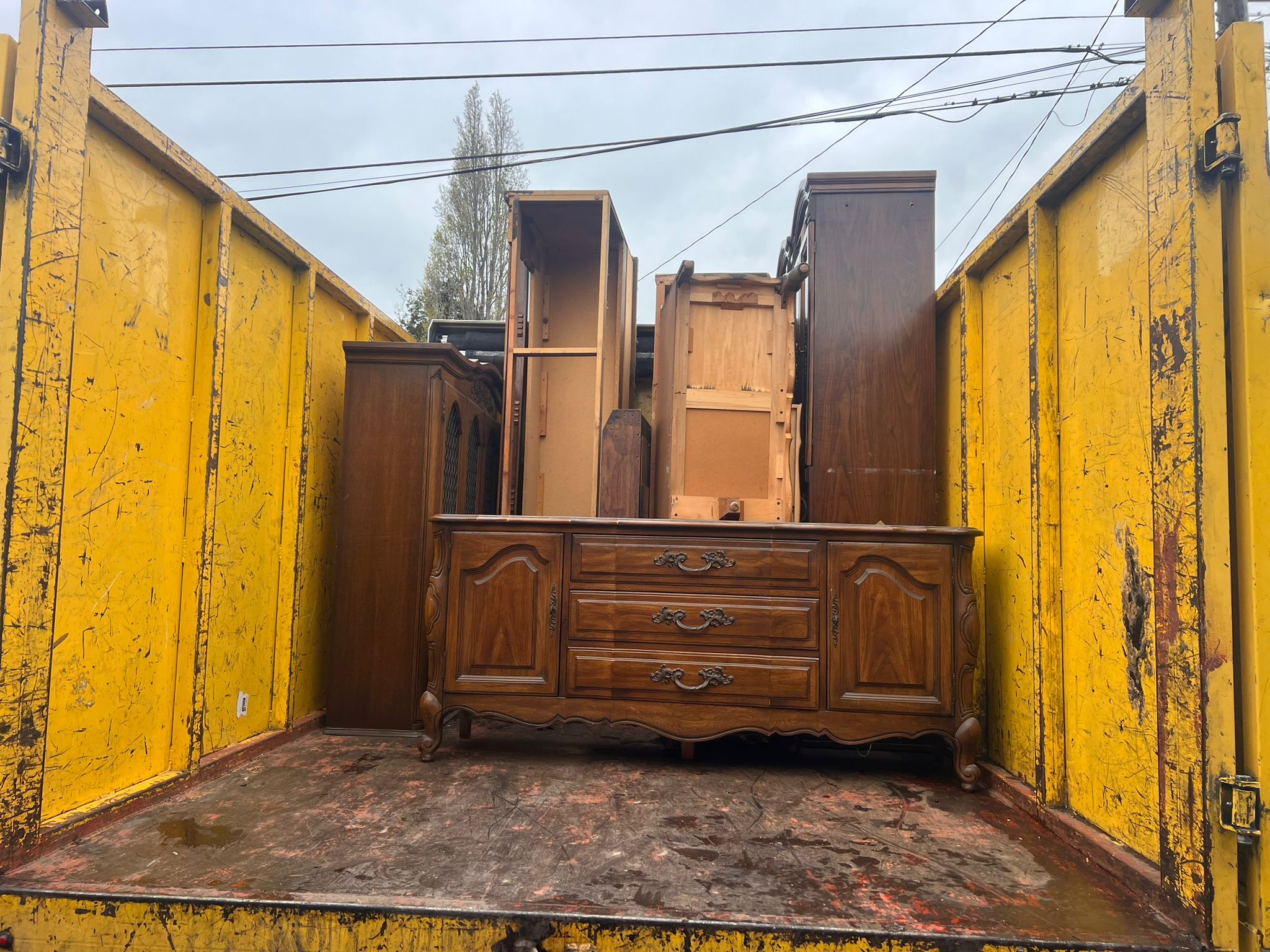 Furniture being loaded into skip for removal
